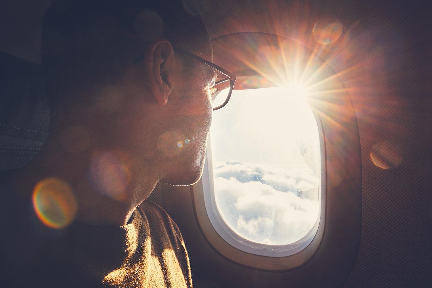Man on airplane looking out window