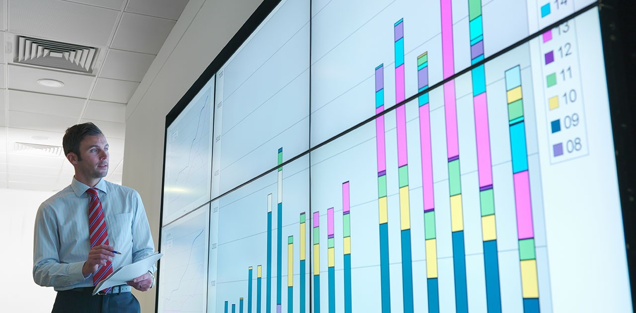 Businessman with graphs on screen