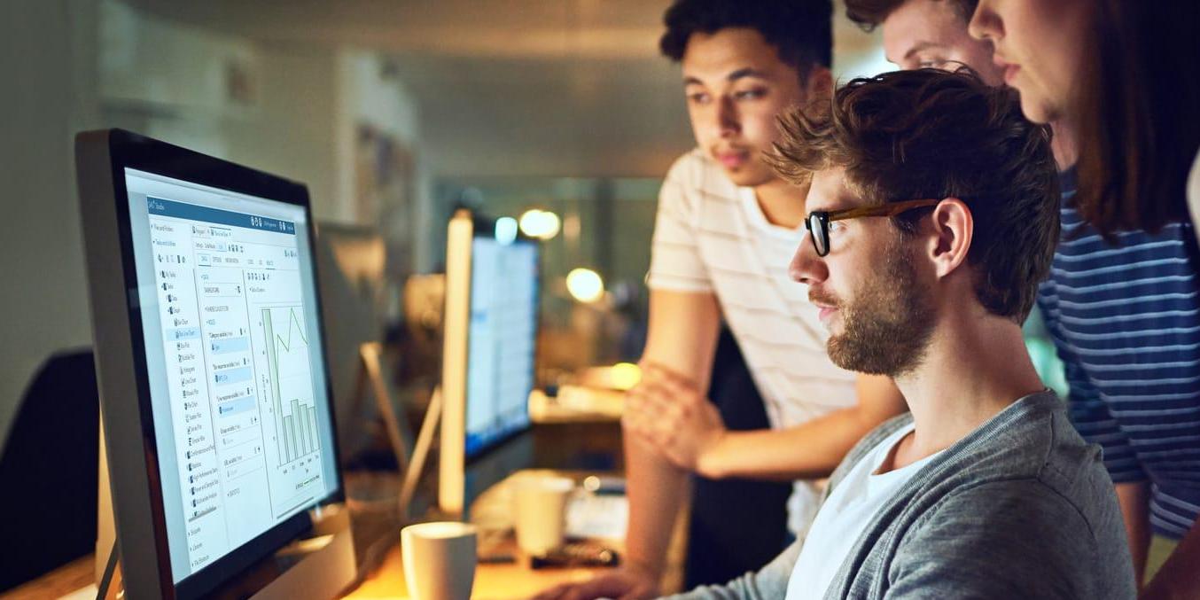 Group of young-data-scientists-around-desktop-computer