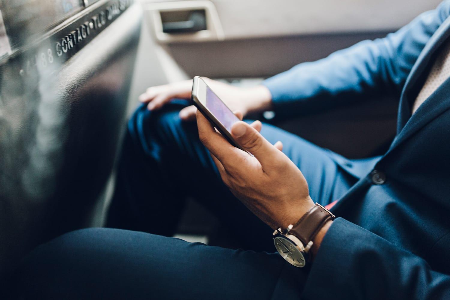 Close up of businessman with mobile phone in taxi Close up of businessman with mobile phone in taxi
