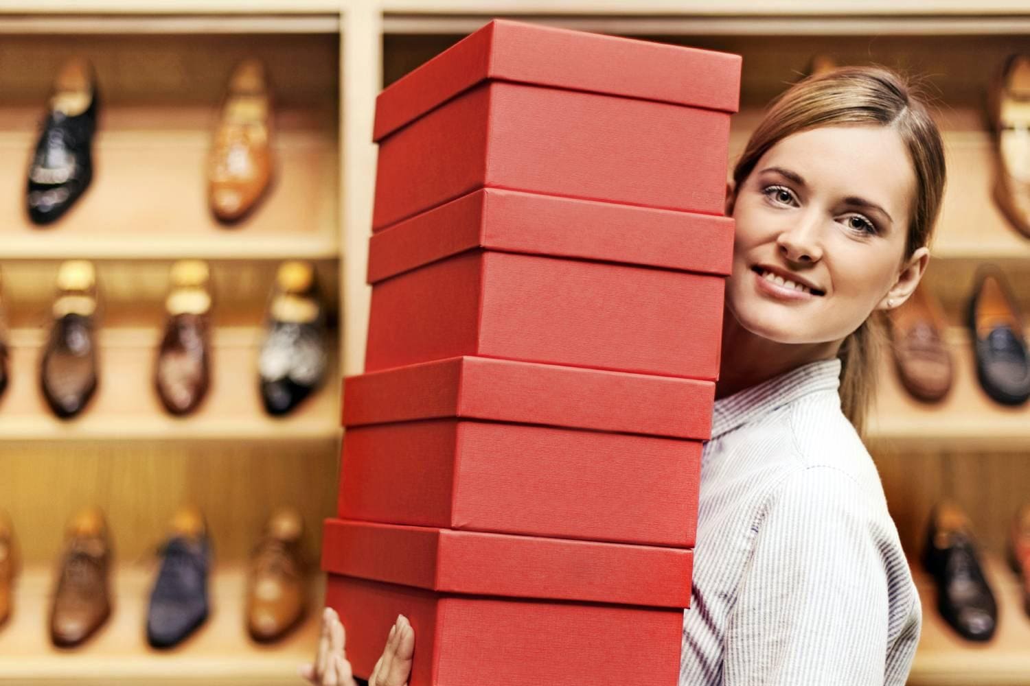 Woman in shoe store holding shoe boxes