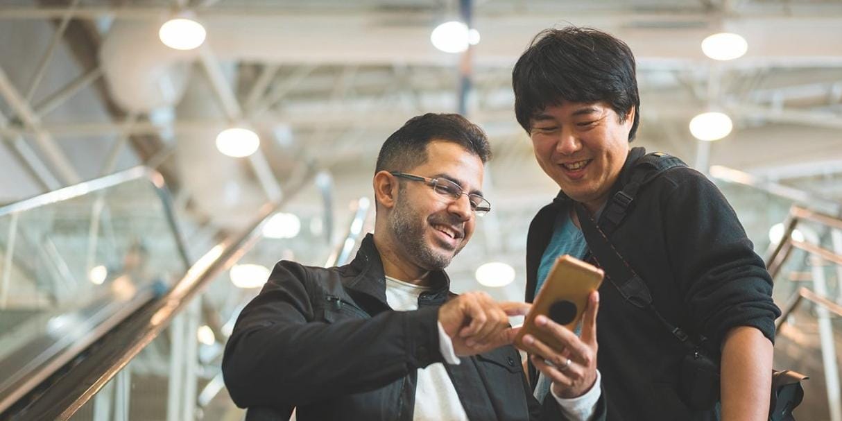 Two men smiling at mobile phone