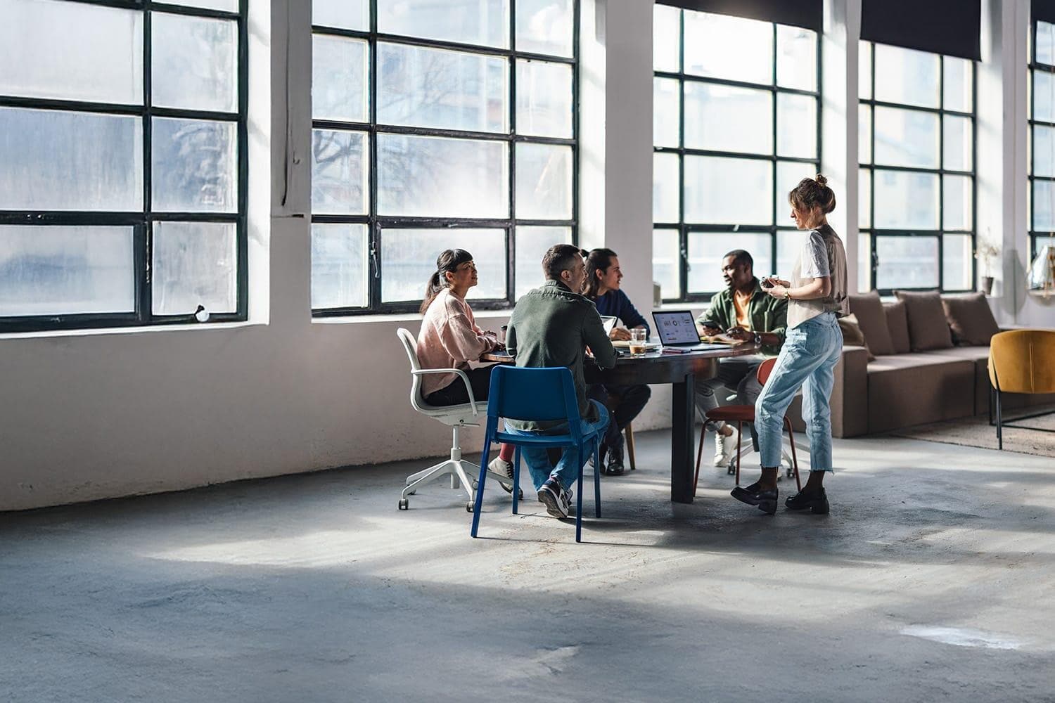 Group of young professionals around table in open office setting