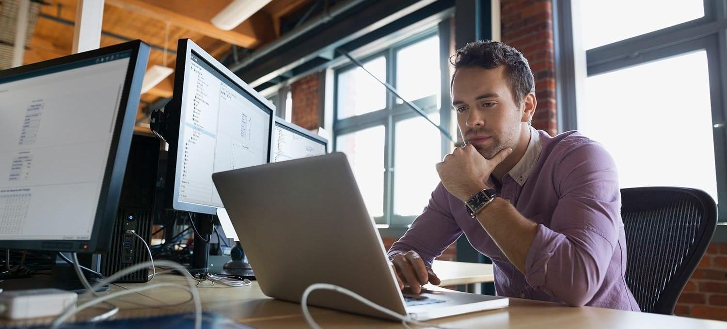 Focused business man working at laptop with SAS® Optimization software