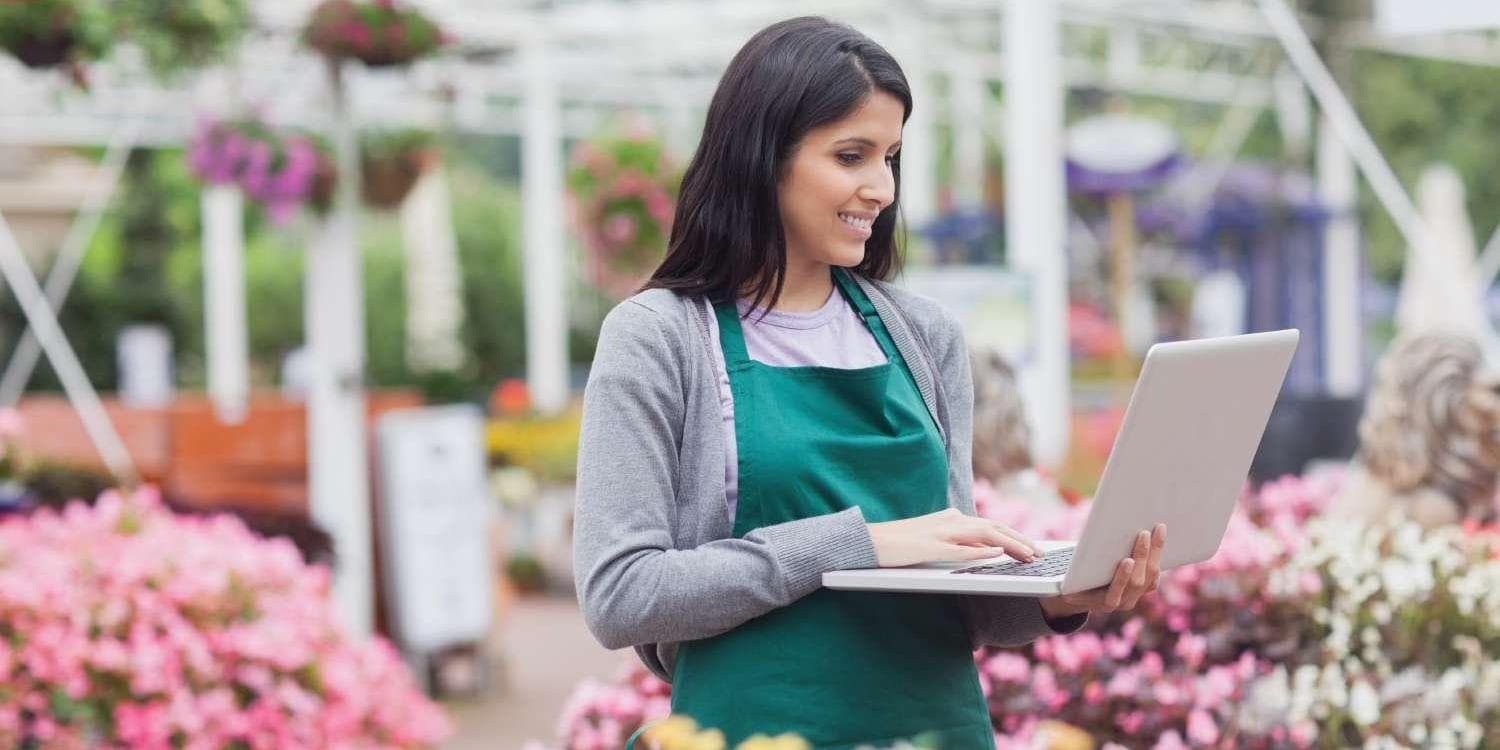 Woman with laptop in garden center