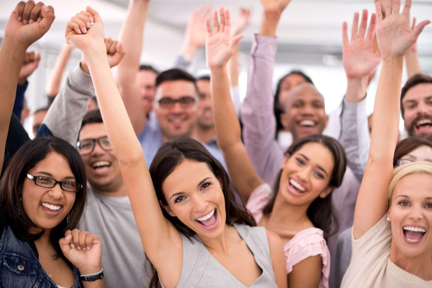 Shot of a group of smiling businesspeople raising their hands together