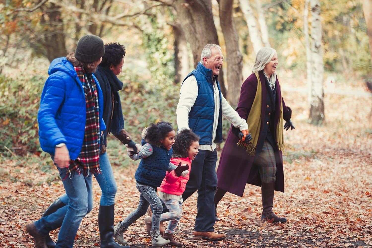 Multi-generation family holding hands walking 