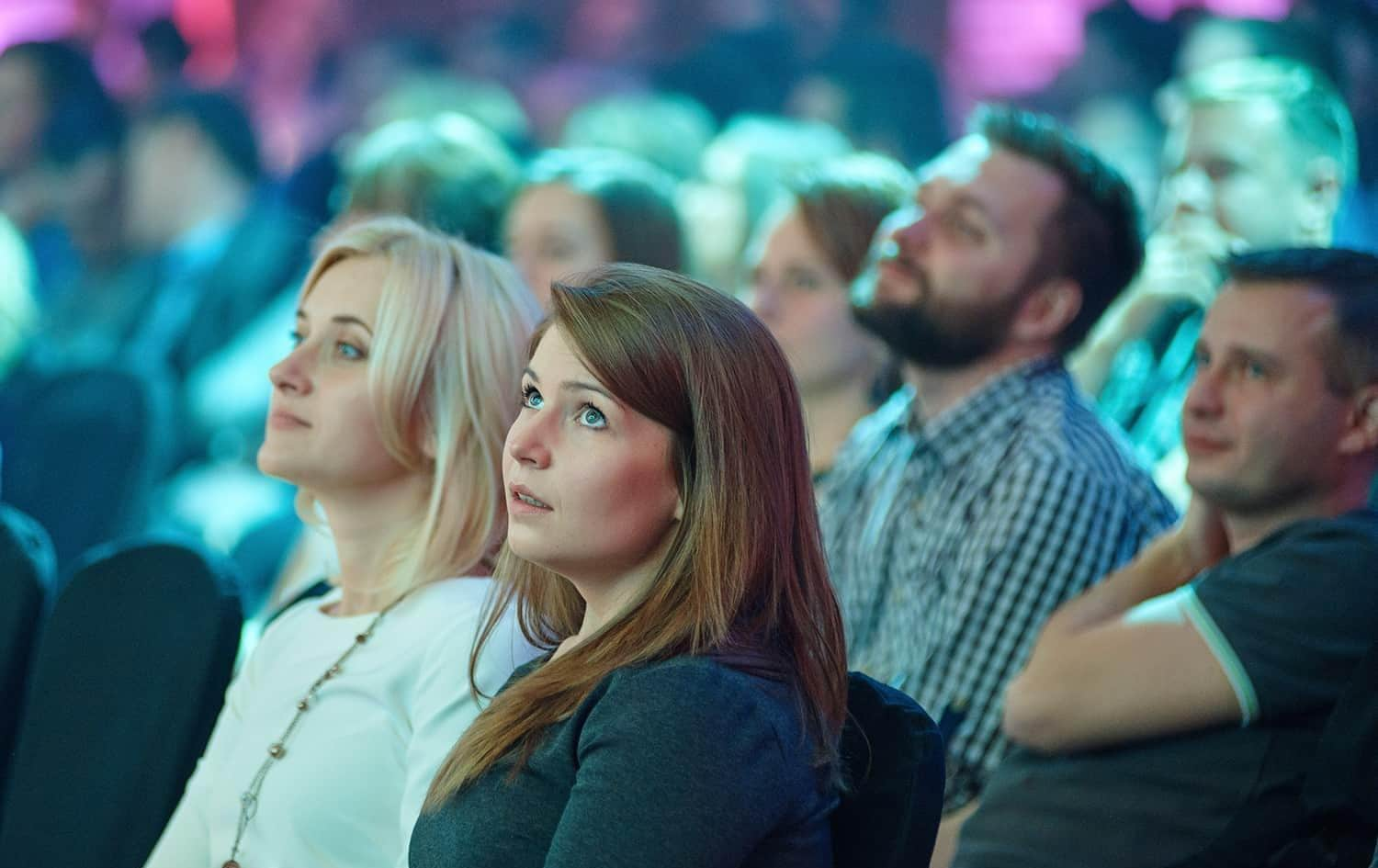 Two women watching presentation in a crowd