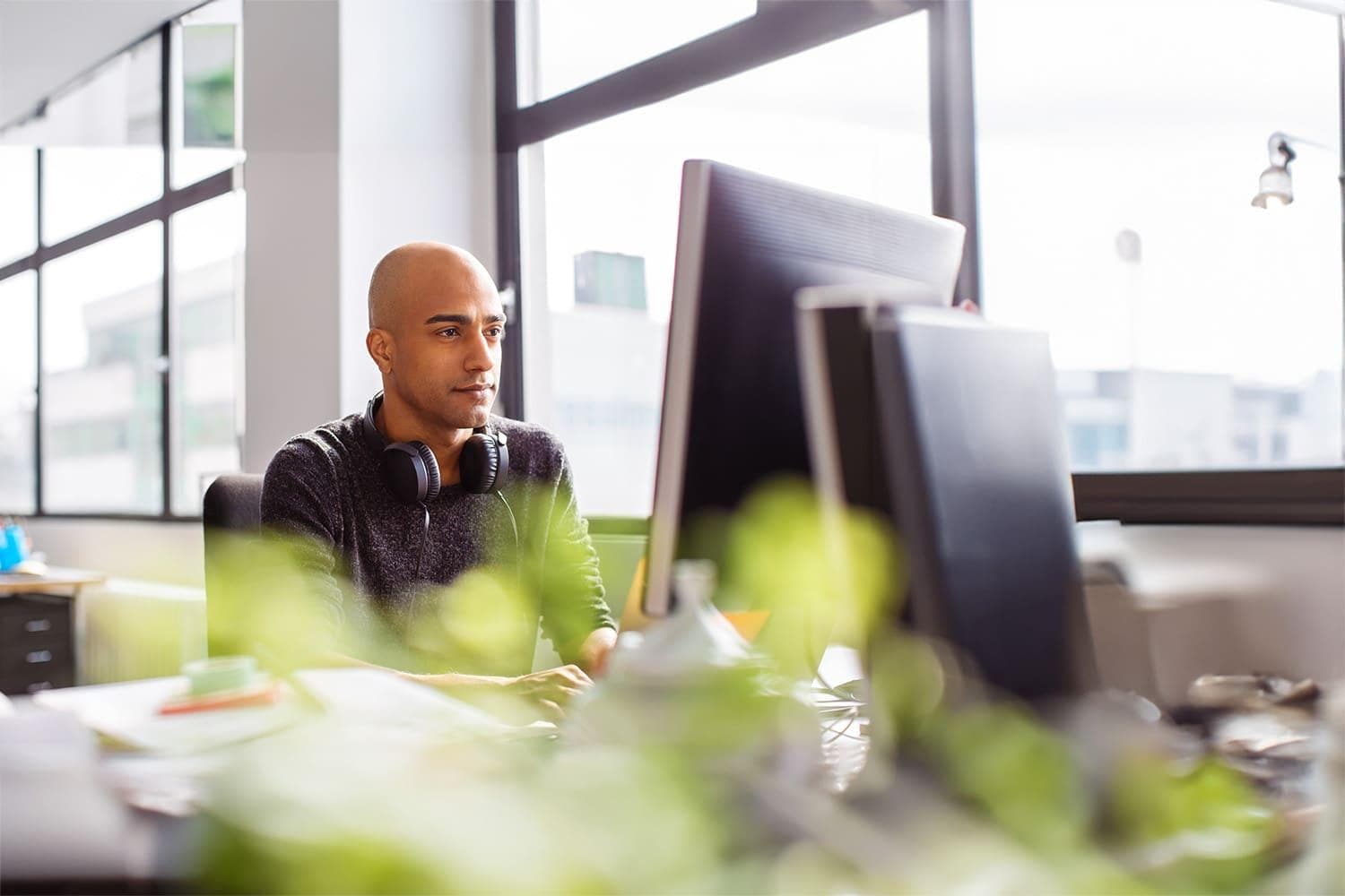 Capital Markets Solutions Man looking at computer wearing headset