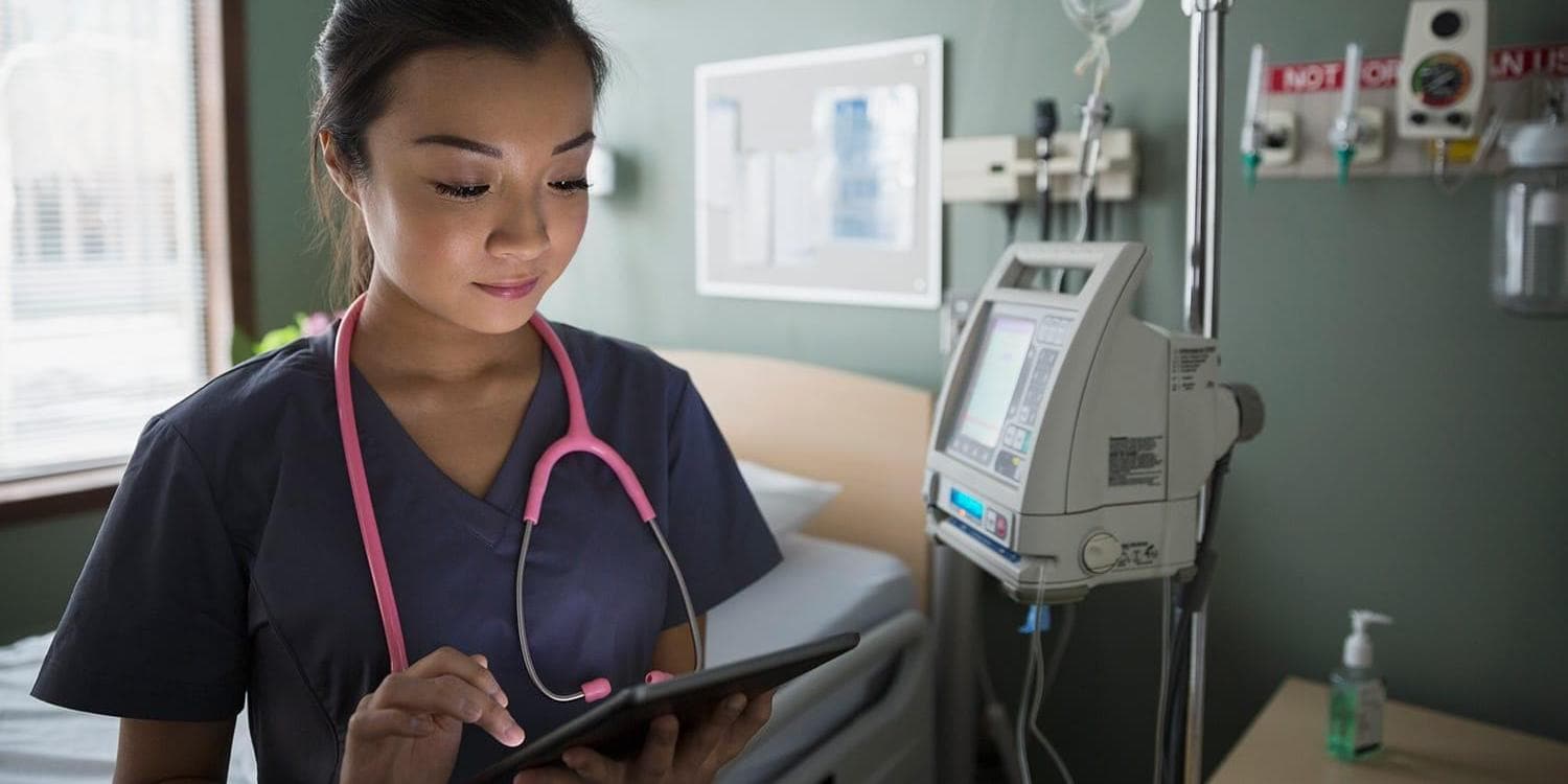 Nurse using digital tablet in hospital room