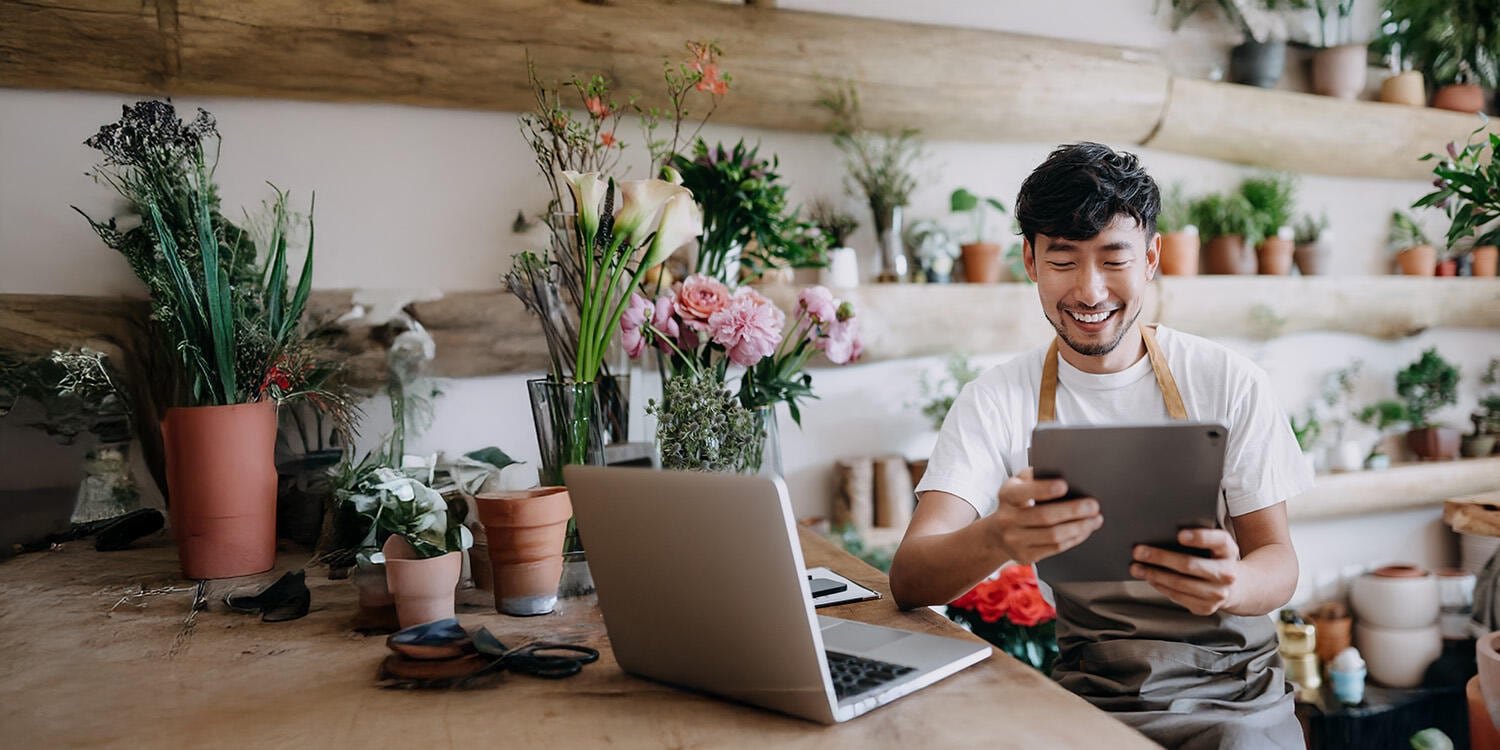 Shopkeeper reviewing data on tablet