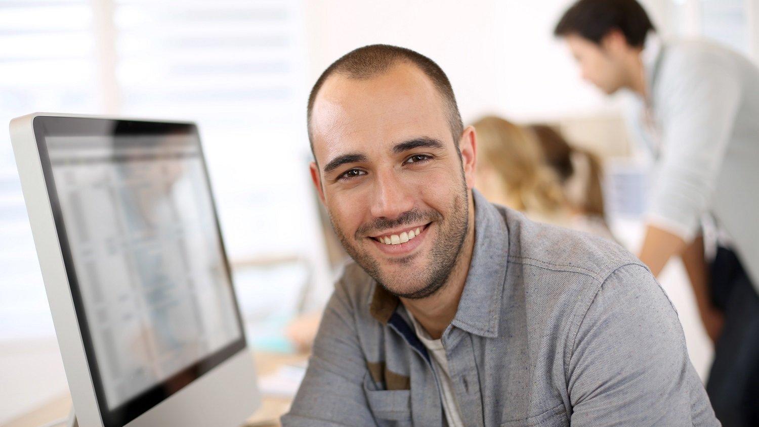 man behind computer smiling