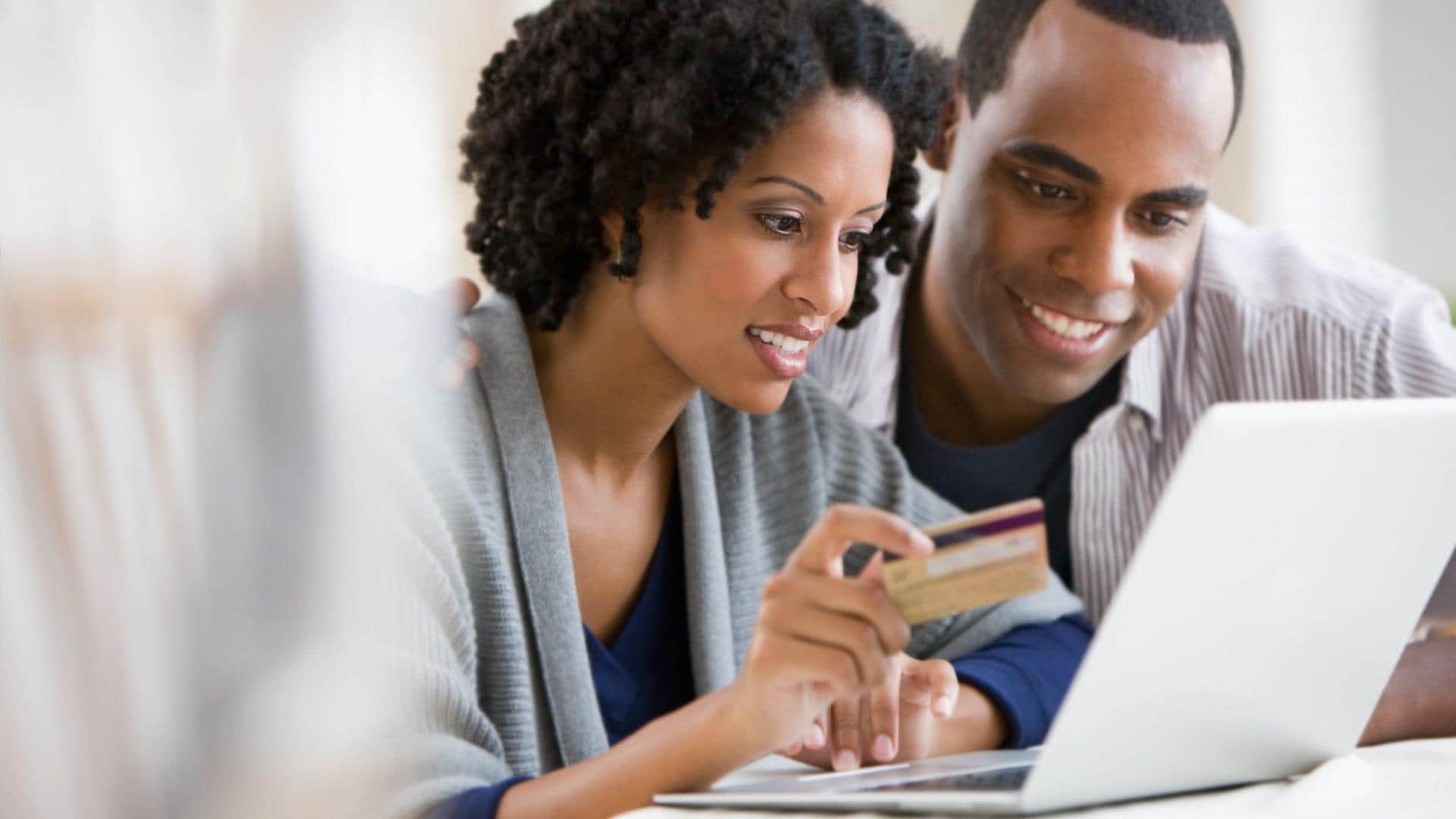 Un jeune couple fait des achats en ligne avec une carte de crédit