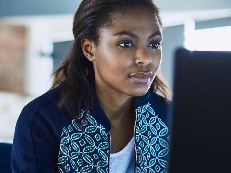 Black Woman in patterned sweater at computer
