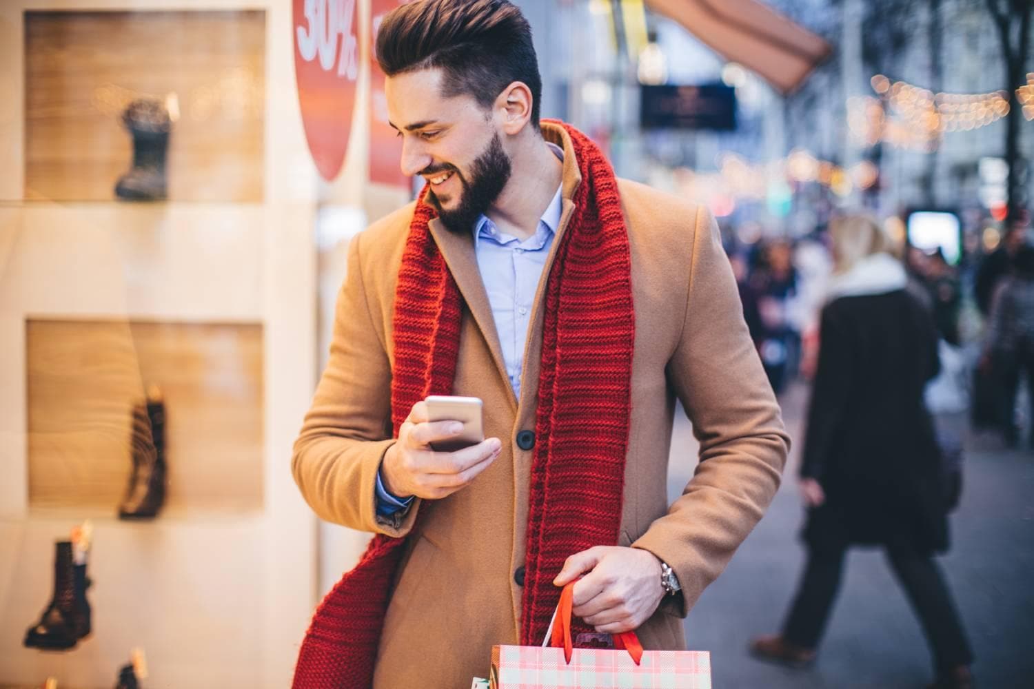 Man wearing red scarf window shopping