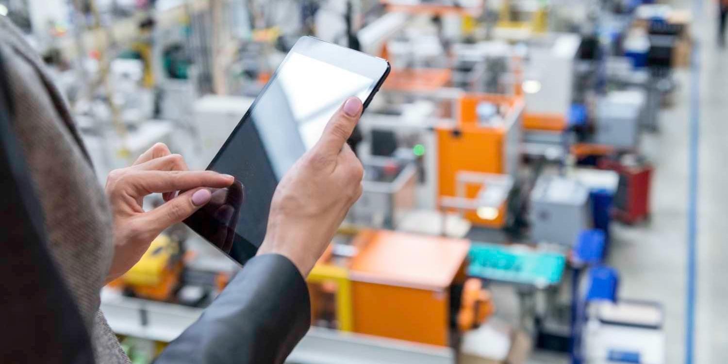 Factory manager uses digital tablet to monitor factory floor