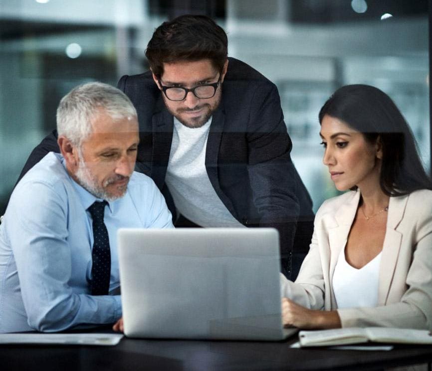 Trio of business people looking at laptop