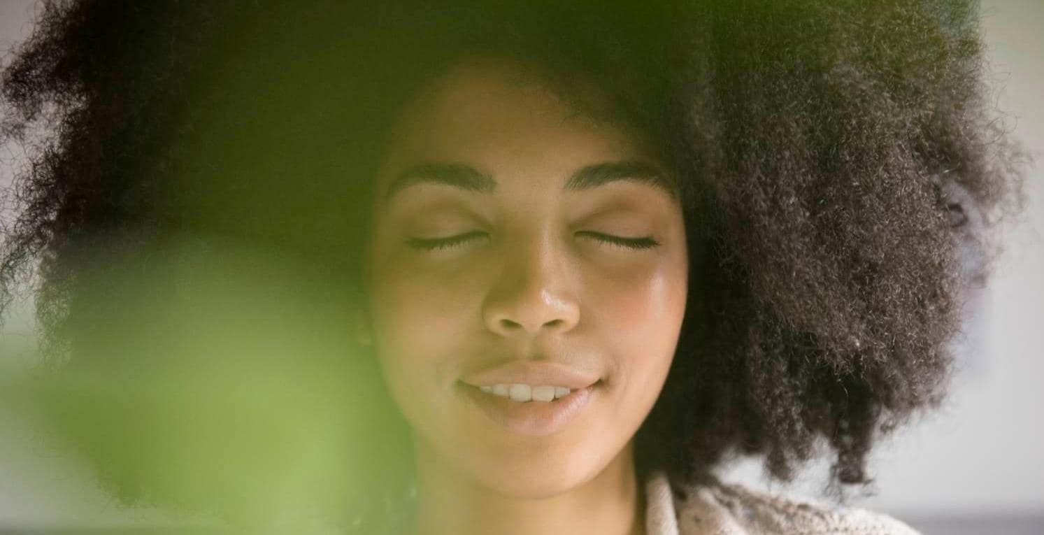 African American woman closing eyes and smiling