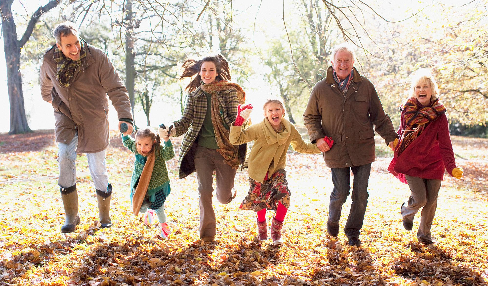 extended family running in park in autumn