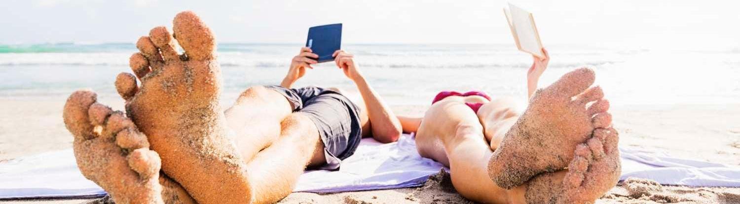Men and women reading in the beach in the summer