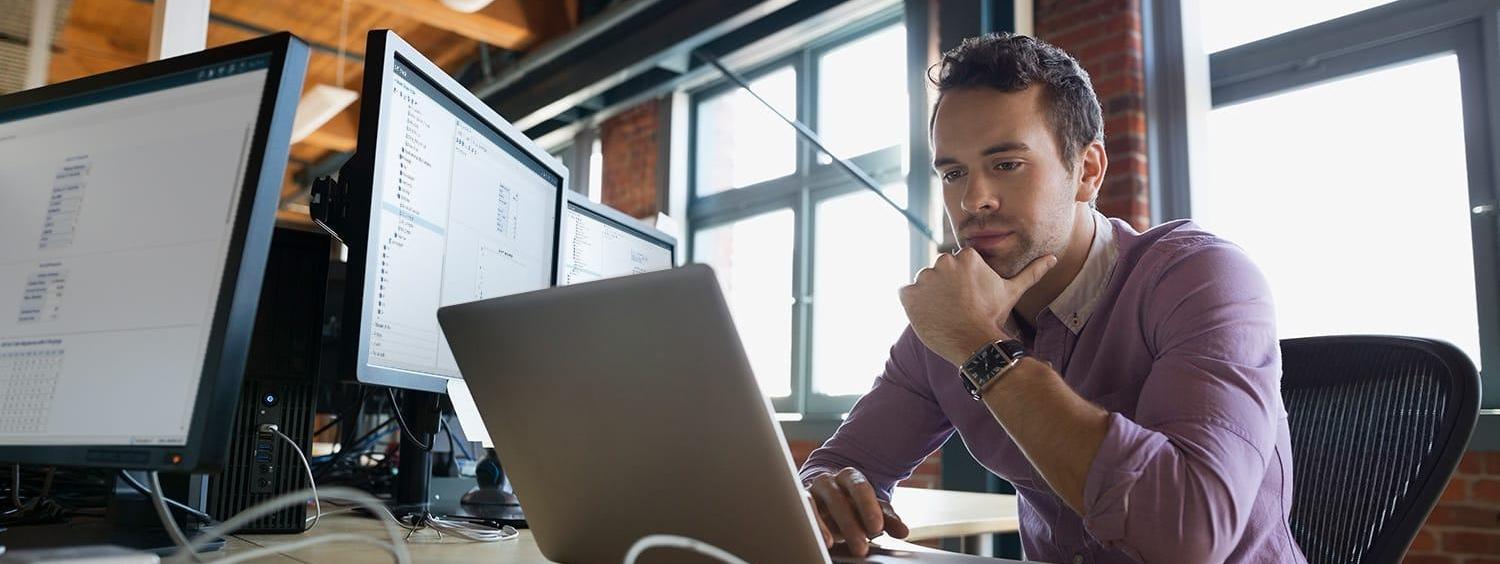 Focused business man working at laptop with SAS® Optimization software Focused business man working at laptop with SAS® Optimization software