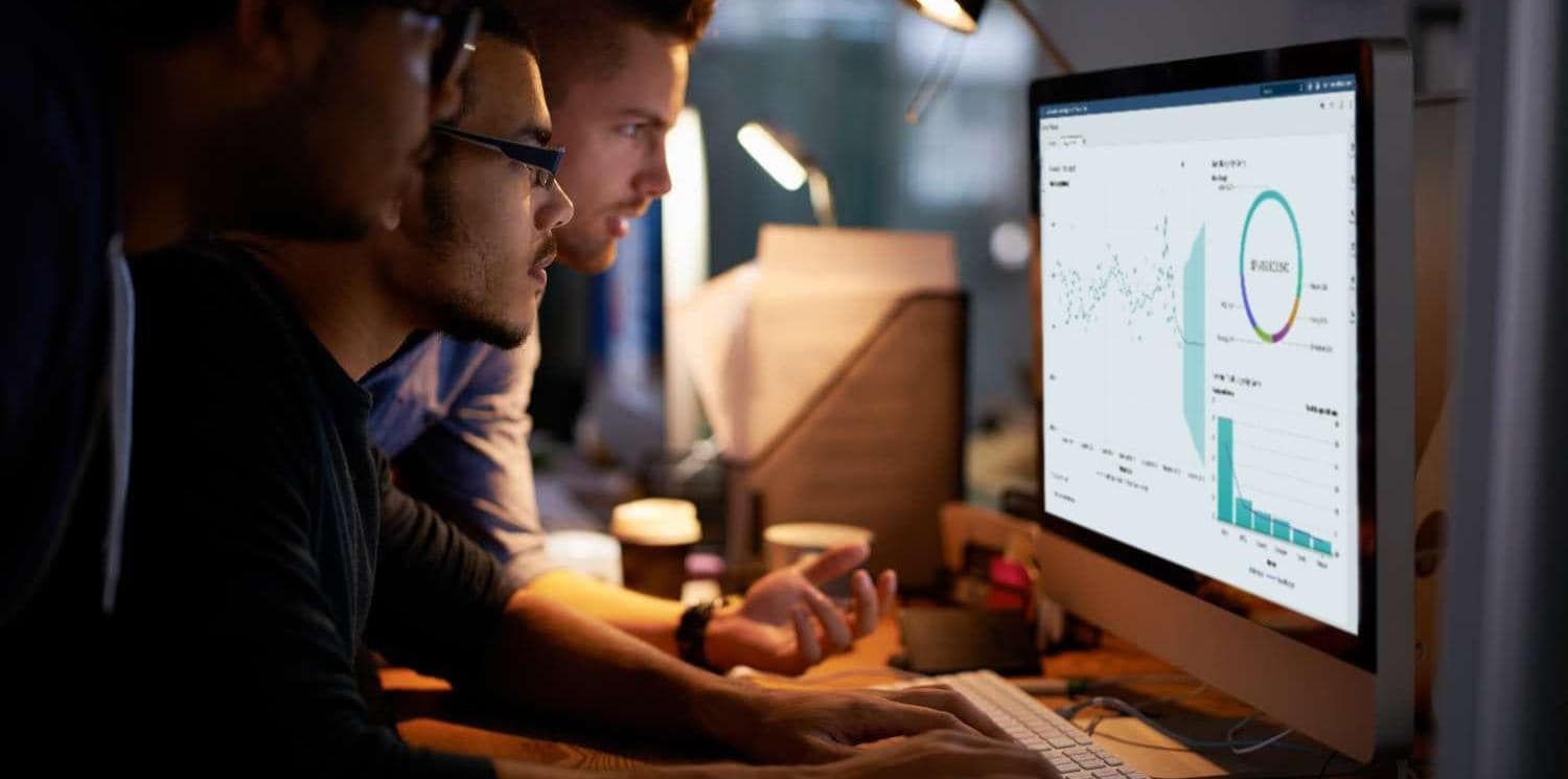 Group of young coworkers working with SAS® Visual Analytics in a dimly lit office Group of young coworkers working with SAS® Visual Analytics in a dimly lit office