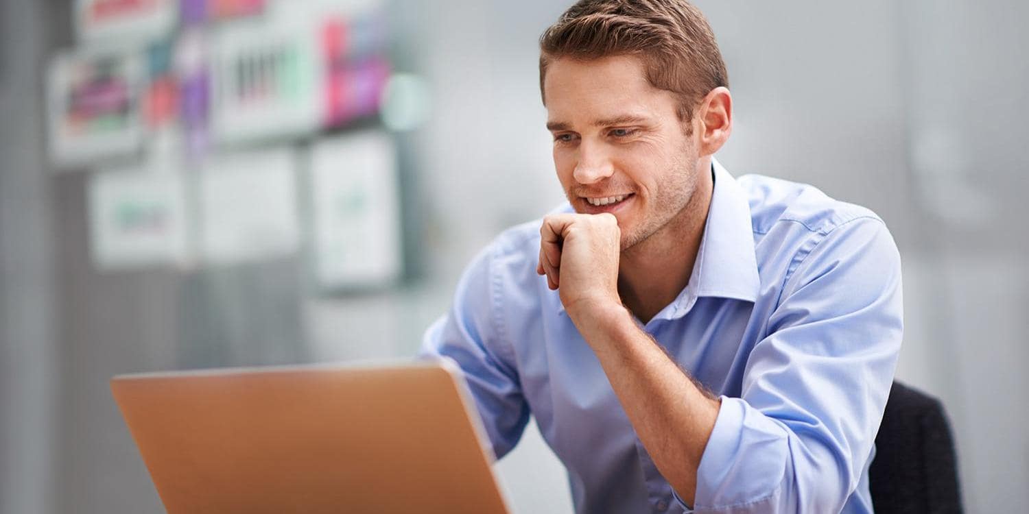 Confident young business man at laptop
