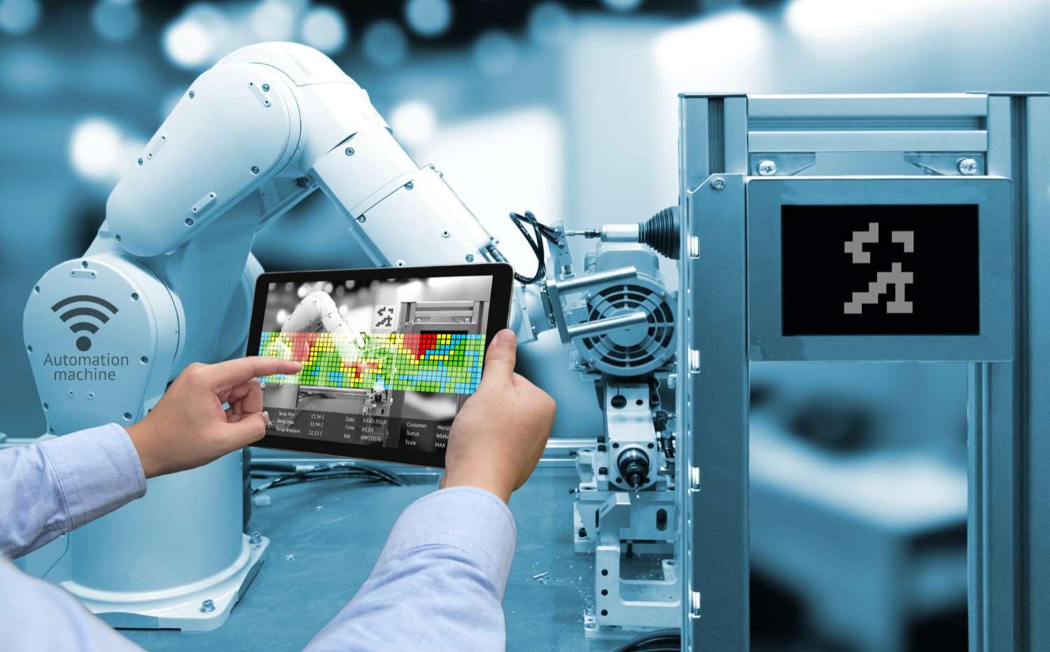 Man hand holding tablet with augmented reality screen software and blue tone of automate wireless -- robot arm in smart factory background  