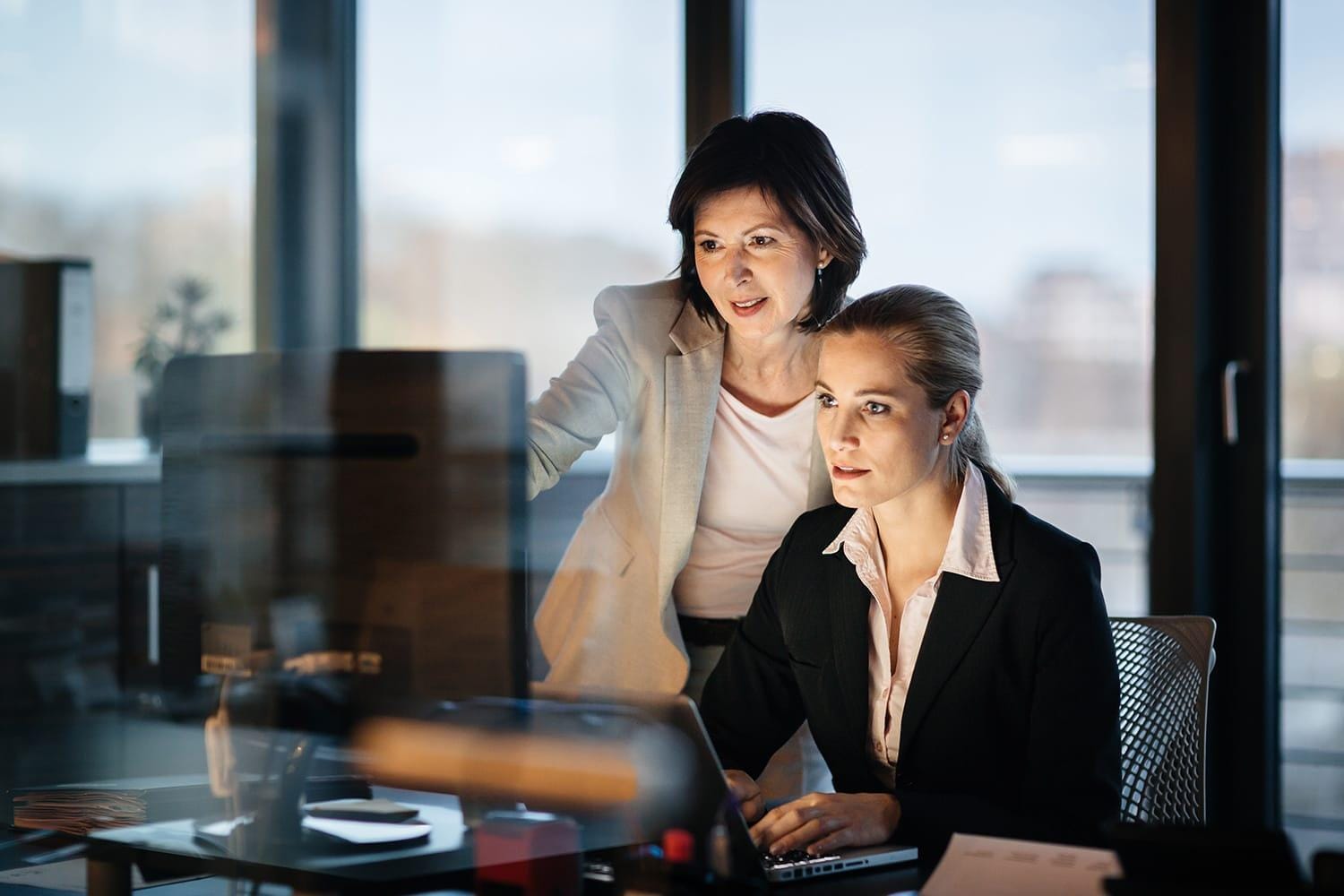 Two business women working late in office