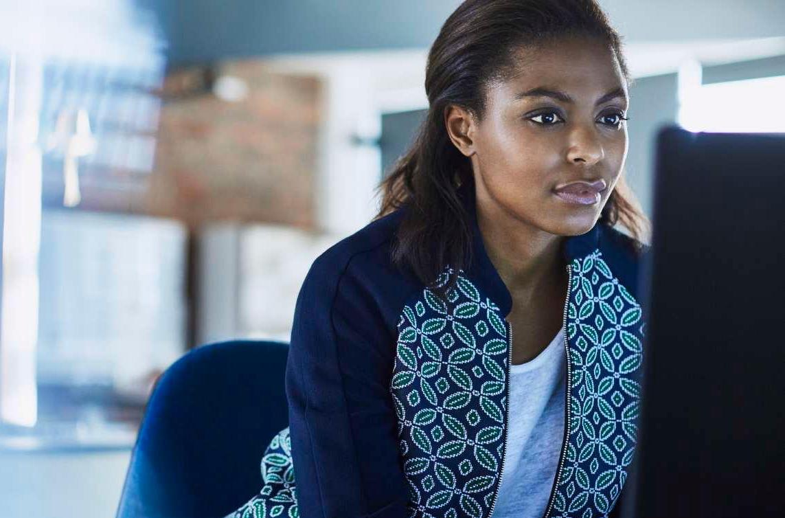 Black Woman in patterned sweater at computer