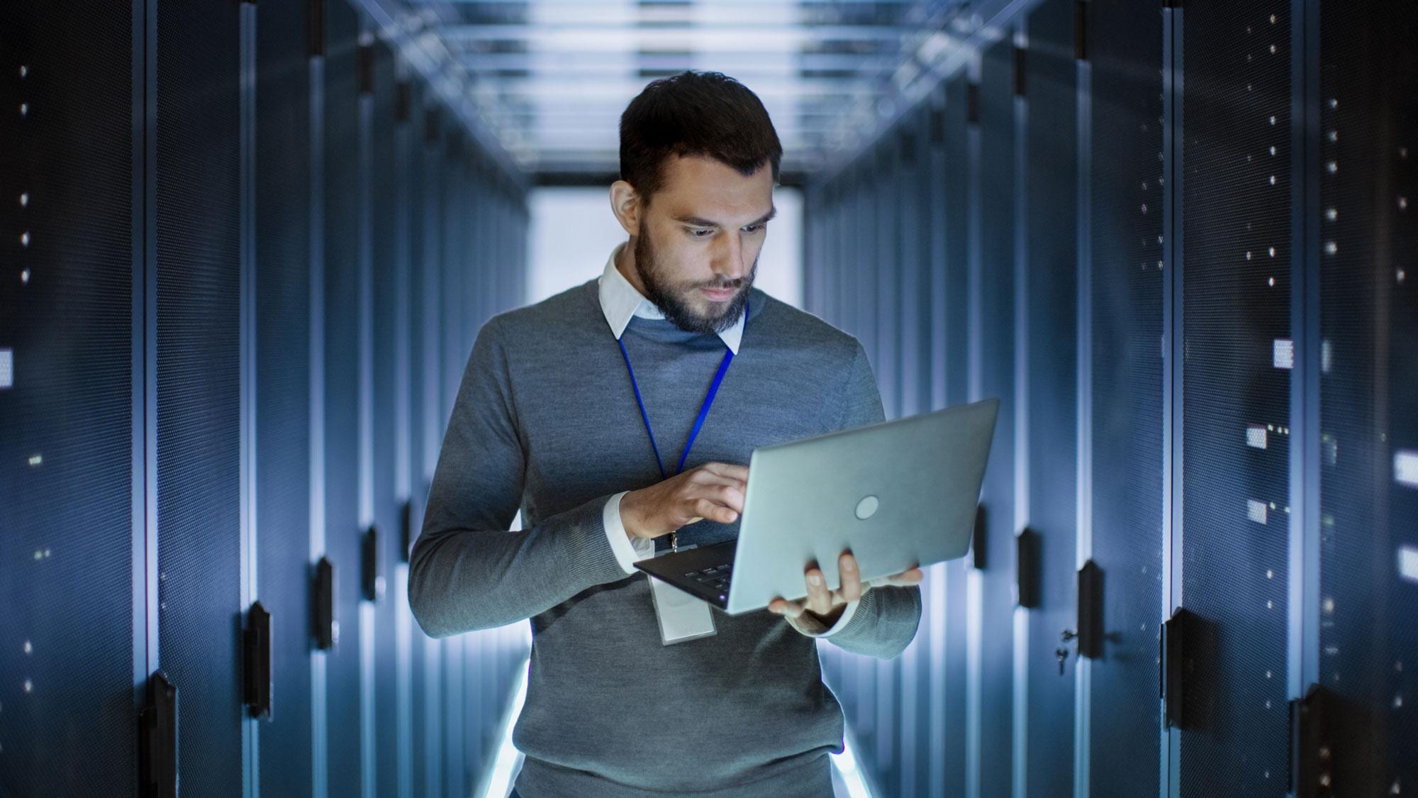 Man holding laptop in data warehouse