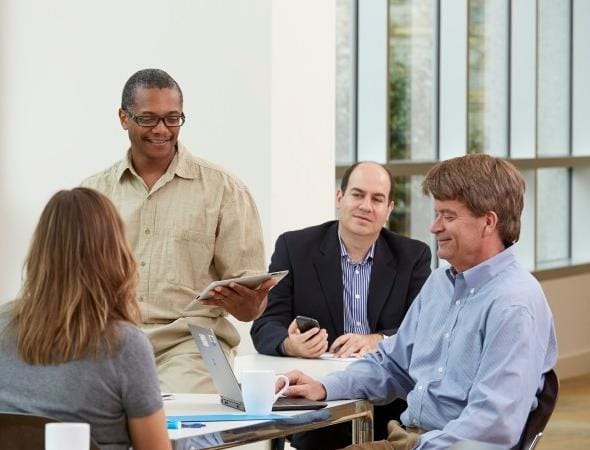 businessman-leads-meeting-with-tablet