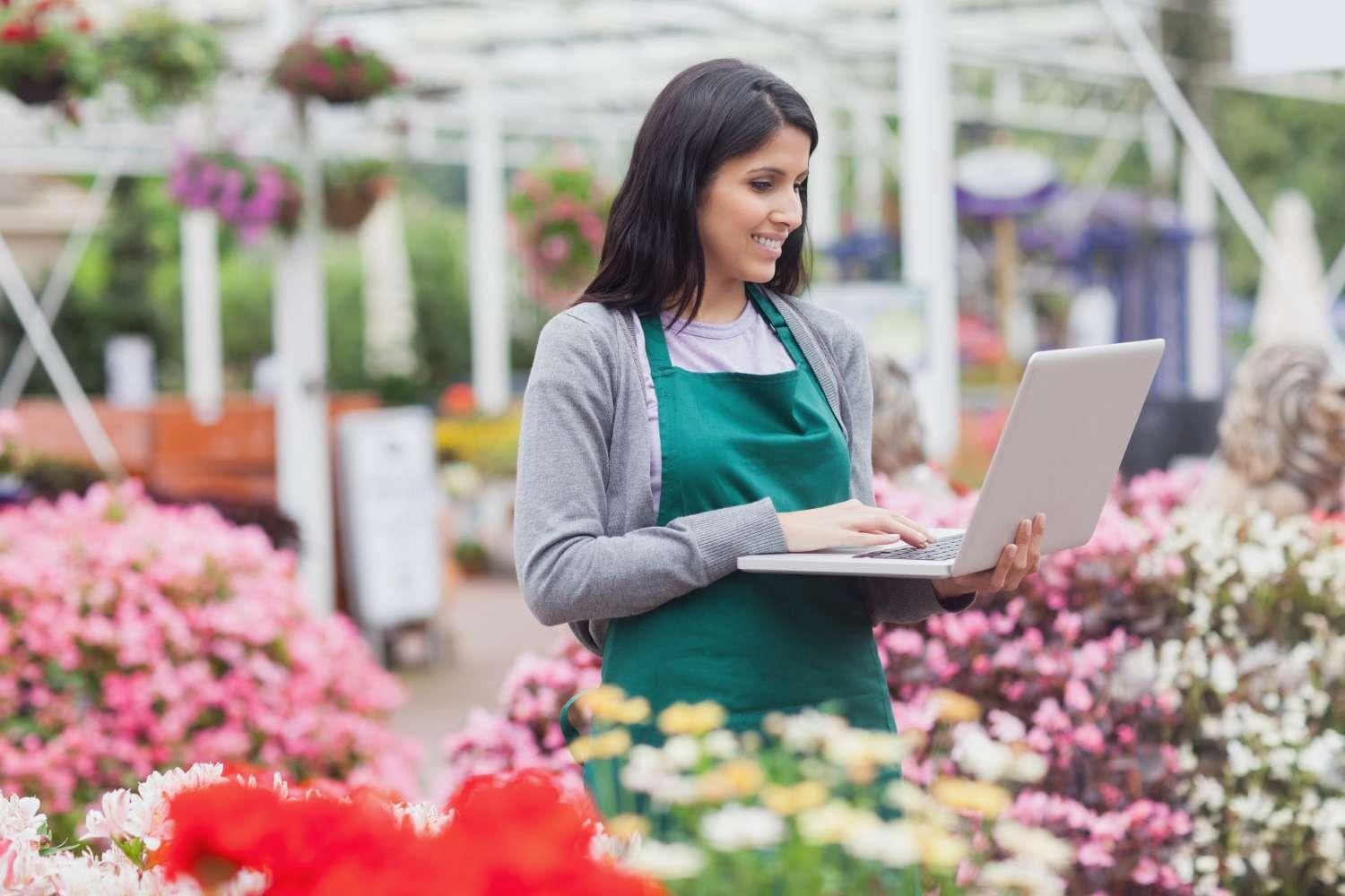 Woman with laptop in flower shop