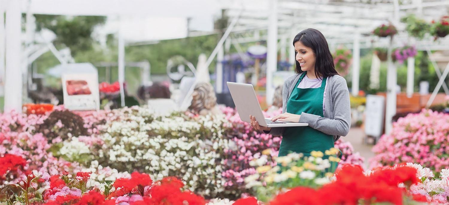 Woman with laptop in flower shop Woman with laptop in flower shop