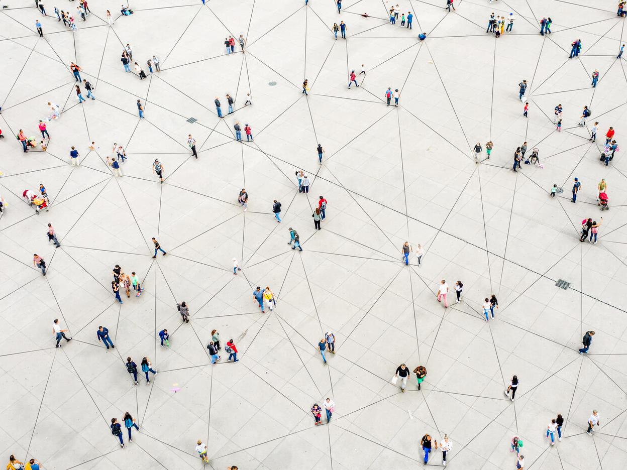 Overhead view of people walking on a grid floor