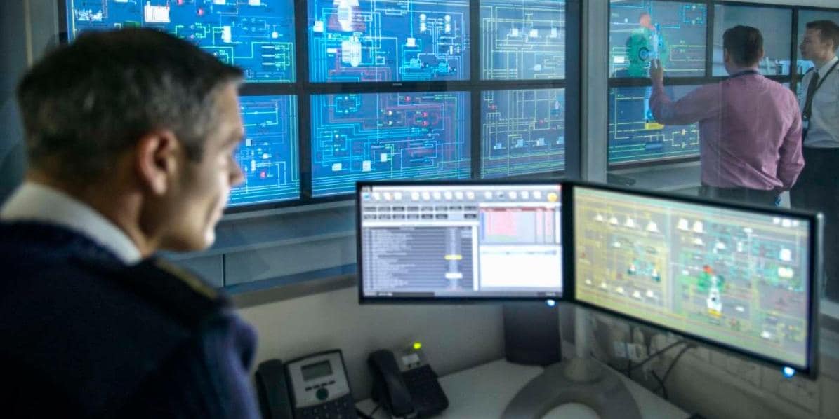 Security control center workers looking at data on computer screens