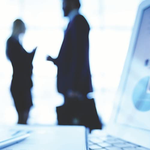 two-people-talking-computer-foreground