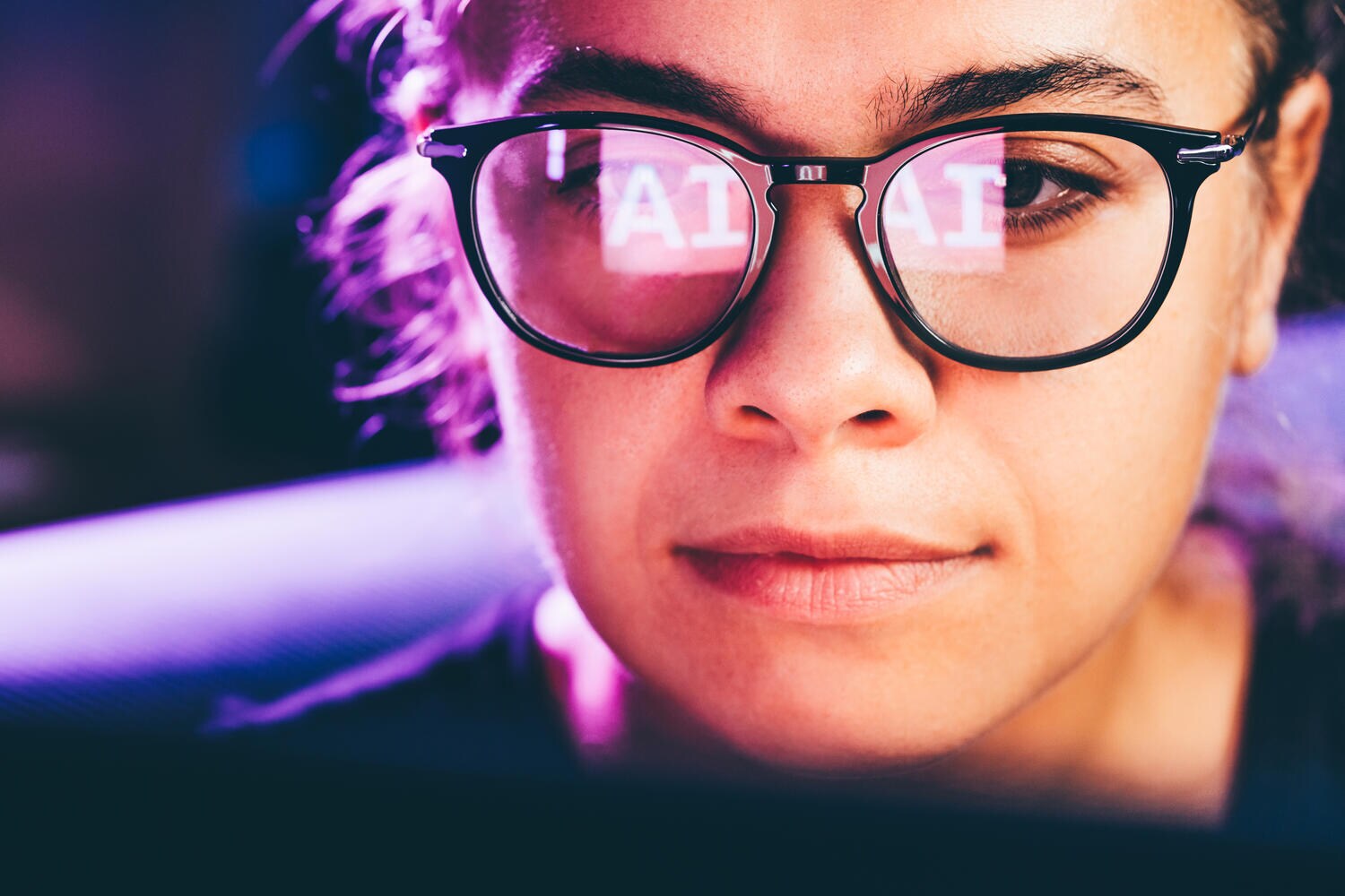 Woman using AI with reflection shown on her glasses
