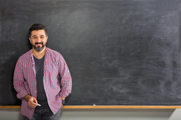 Bearded professor standing at chalkboard