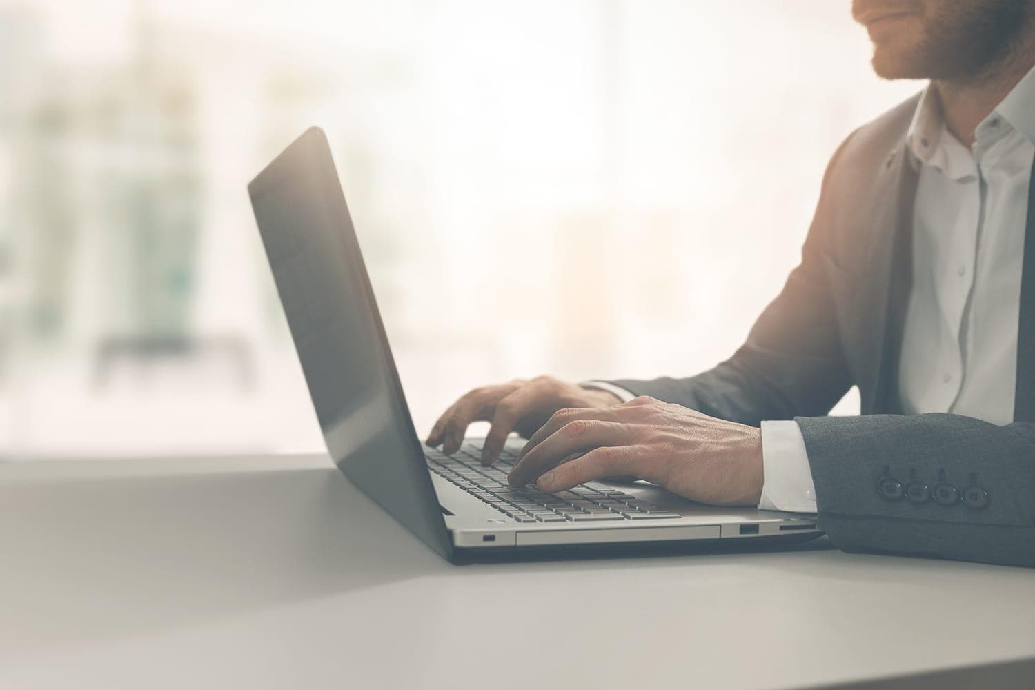 Young businessman using laptop in open office setting