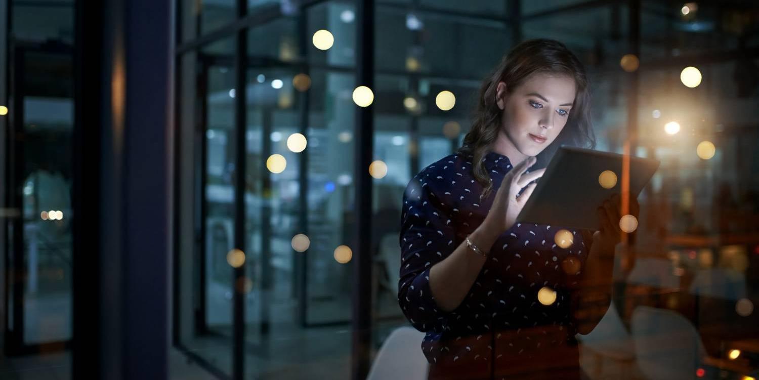 Woman looking at tablet at night