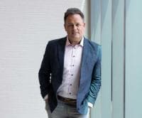 Portrait of Bryan Harris in Lobby leaning against a wall