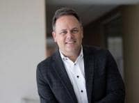 Vertical Portrait of Bryan Harris leaning on mezzanine rail
