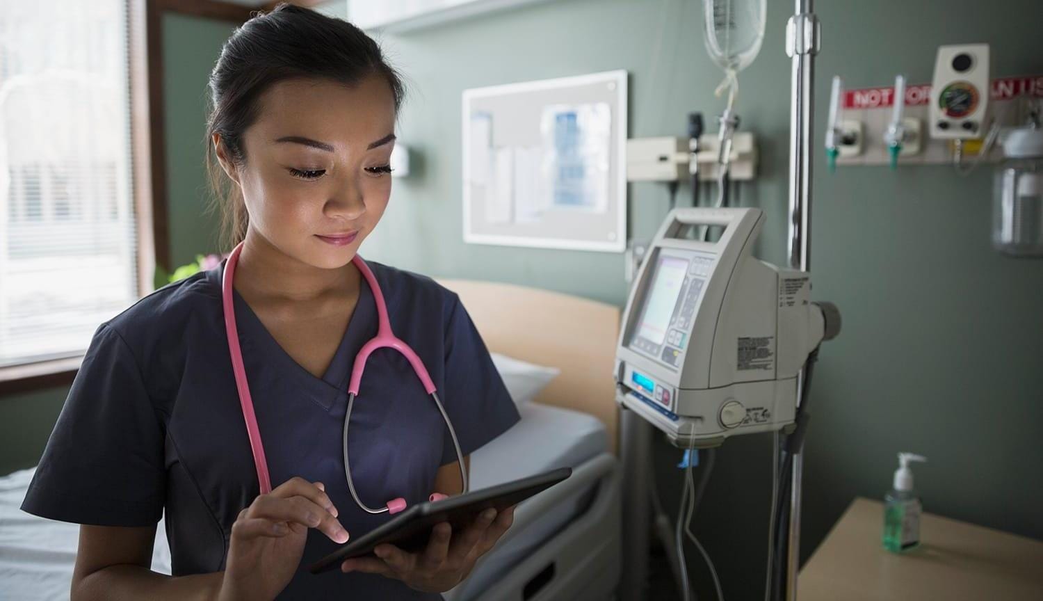 Nurse using digital tablet in hospital room