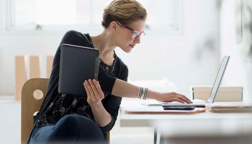Woman working on laptop and tablet device