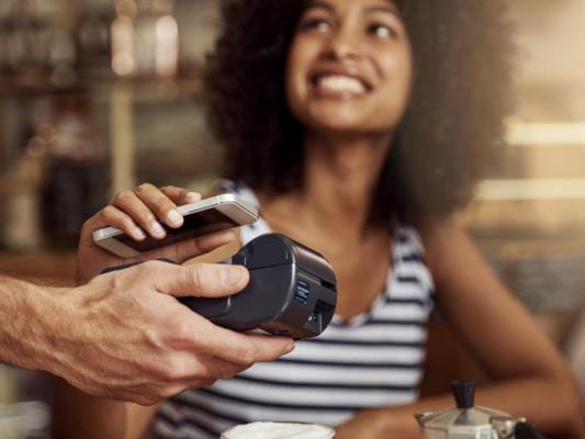 Woman paying bill by scanning her phone