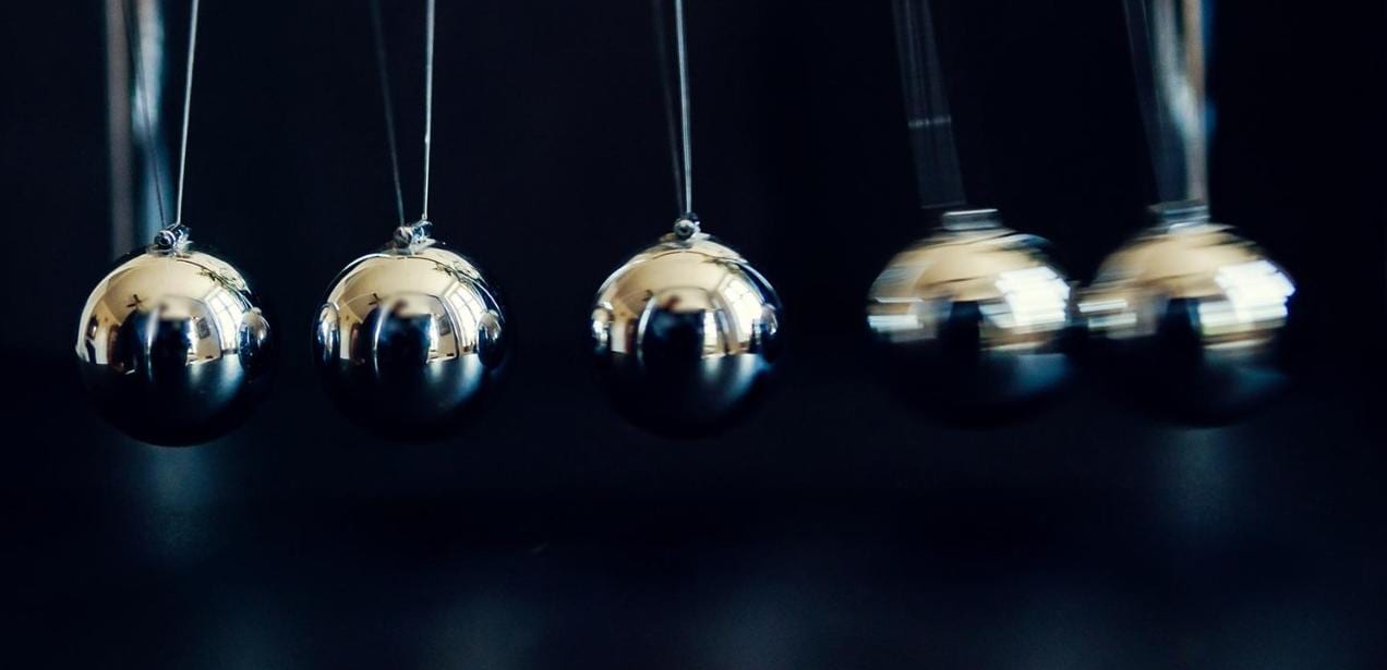 Dramatic slow motion shot of a Newton's Cradle over a dark background