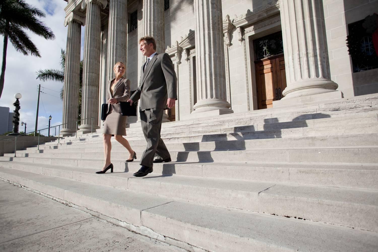 Businessman and Businesswoman walking down stairs of government building