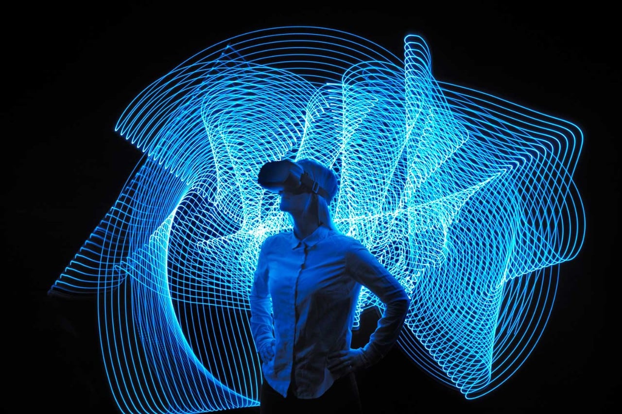 Woman standing wearing VR headset with organic light lines