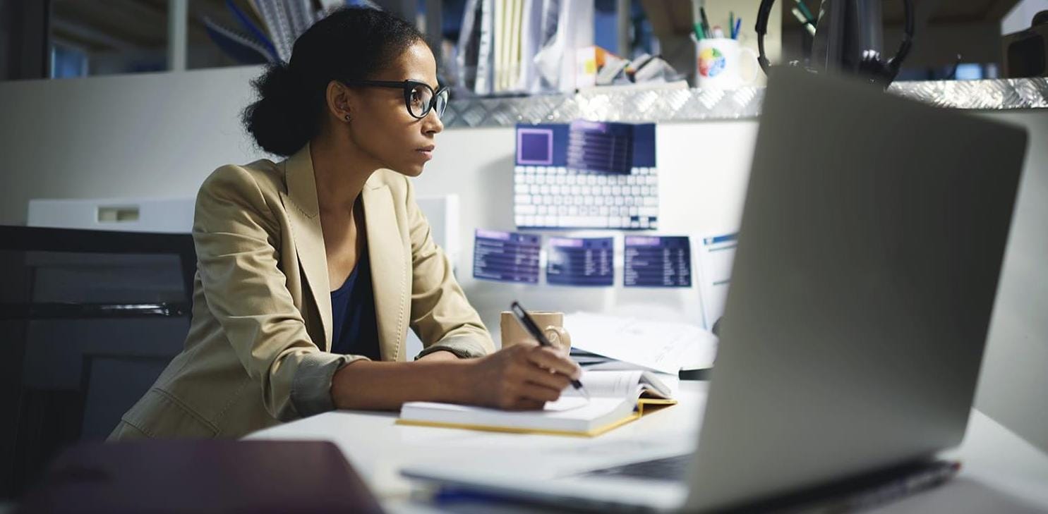 Female data scientist preparing reports on computer